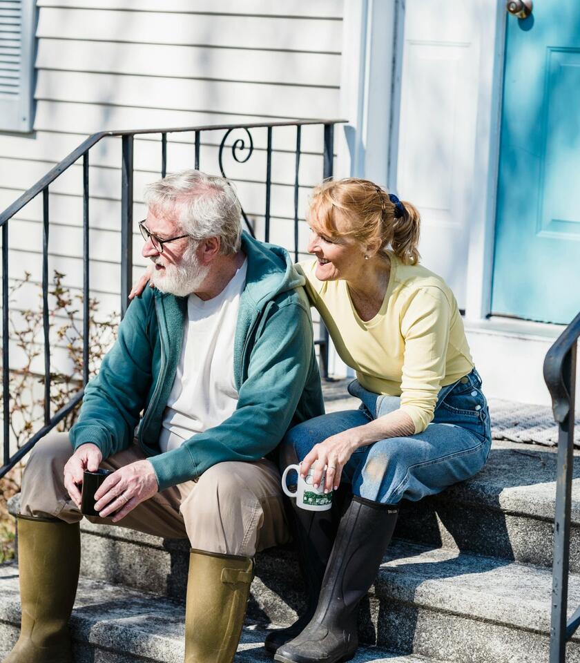 A happy couple enjoying retirement together on their front steps